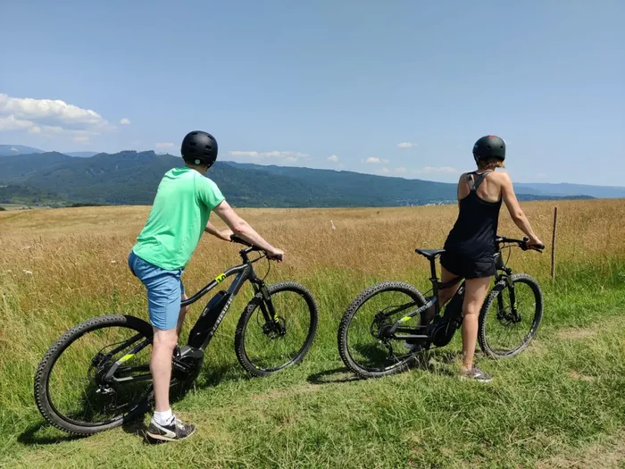 Two riders on Haibike e-bikes pausing in a summer meadow above Sovata